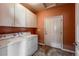 Laundry room features modern washer and dryer units, complemented by overhead storage cabinets at 1430 Bluefield Ave, Longmont, CO 80504