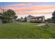 A spacious backyard with a large lawn, wooden fence, deck, and mature tree offers outdoor relaxation at 1973 Bahama St, Aurora, CO 80011