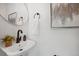Modern powder room featuring a round mirror, bronze fixtures, and elegant decor at 1973 Bahama St, Aurora, CO 80011