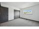 A well-lit bedroom featuring gray carpet and closet doors and a bright window at 1973 Bahama St, Aurora, CO 80011