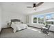 Bright bedroom featuring a ceiling fan, plush carpet, and a large window with neighborhood views at 1973 Bahama St, Aurora, CO 80011