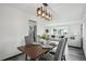 Open dining space with rustic wood table, stylish light fixture, and gray laminate floors at 1973 Bahama St, Aurora, CO 80011