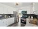 Well-lit kitchen featuring white cabinetry, stainless steel appliances, and a stylish backsplash for added charm at 1973 Bahama St, Aurora, CO 80011