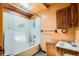 View of a bathroom with a shower and sink. The room is outdated, the tile is old and broken at 1645 Little Bear Creek Rd, Idaho Springs, CO 80452