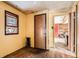 View of a bedroom with yellow walls, hardwood floors, a window, a closet and a doorway at 1645 Little Bear Creek Rd, Idaho Springs, CO 80452
