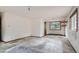 A spacious bedroom featuring a large window overlooking a wooded area and worn carpeting at 1645 Little Bear Creek Rd, Idaho Springs, CO 80452