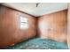 View of bedroom with wood paneled walls, drop tile ceiling, a window and green carpeting at 1645 Little Bear Creek Rd, Idaho Springs, CO 80452