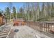 View of the wooden deck featuring a hot tub, railing, and partially removed deck boards surrounded by a forest at 1645 Little Bear Creek Rd, Idaho Springs, CO 80452