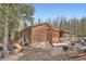 Rustic log cabin exterior with wooden steps and forested backdrop under clear blue skies at 1645 Little Bear Creek Rd, Idaho Springs, CO 80452