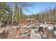 Exterior view of the home cluttered with discarded furniture, debris, and construction materials at 1645 Little Bear Creek Rd, Idaho Springs, CO 80452