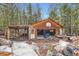 Exterior view of a garage and carport with basketball hoop surrounded by discarded furniture and debris at 1645 Little Bear Creek Rd, Idaho Springs, CO 80452