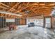 Interior view of a garage featuring a snowblower, open garage door, and visible debris outside at 1645 Little Bear Creek Rd, Idaho Springs, CO 80452