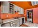 Retro kitchen with orange walls, vintage cabinets, and worn wooden flooring at 1645 Little Bear Creek Rd, Idaho Springs, CO 80452