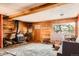 Living room featuring wood paneled walls, wood-burning stove and natural lighting at 1645 Little Bear Creek Rd, Idaho Springs, CO 80452