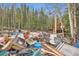 Yard cluttered with discarded furniture, debris, and construction materials near a wooded area at 1645 Little Bear Creek Rd, Idaho Springs, CO 80452