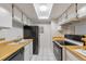 Efficient kitchen layout with ample cabinet space, white tile floors and a black appliance package at 14454 E Colorado Dr # 103, Aurora, CO 80012