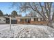 Traditional home with a brick facade, garage, and a snowy front yard at 4712 S Wabash St, Denver, CO 80237