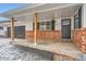 Charming front porch features brick accents and dark shutters at 4712 S Wabash St, Denver, CO 80237