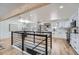 Bright kitchen featuring white cabinets, stainless steel appliances, wood floors, and a black metal staircase railing at 4712 S Wabash St, Denver, CO 80237