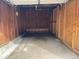 Interior of a one-car garage featuring wood walls, concrete flooring, and an overhead door at 100 E Highline Cir # 105, Centennial, CO 80122