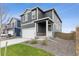 Two-story home with gray siding, white garage door, and landscaped lawn at 847 Ledge St, Lochbuie, CO 80603