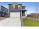 Two-story home with gray siding, white garage door, and landscaped lawn at 847 Ledge St, Lochbuie, CO 80603