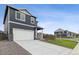 Two-story home with gray siding, white garage door, and landscaped lawn at 847 Ledge St, Lochbuie, CO 80603