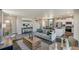 Open living room with gray sofa, wooden coffee table, and kitchen views at 847 Ledge St, Lochbuie, CO 80603