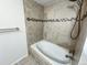 Elegant bathroom features a soaking tub and tiled walls with decorative border at 6640 S Heritage W Pl, Centennial, CO 80111