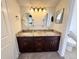 Bathroom featuring a double sink vanity with granite countertop and updated lighting at 6640 S Heritage W Pl, Centennial, CO 80111
