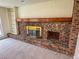 Brick fireplace with golden screen, wooden mantel, and built-in shelving at 6640 S Heritage W Pl, Centennial, CO 80111