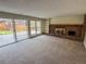 Spacious living room featuring a brick fireplace, built-in shelving, and sliding glass doors to the backyard at 6640 S Heritage W Pl, Centennial, CO 80111