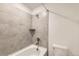 Bathroom featuring bathtub-shower combination, neutral tile, and basic fixtures at 17632 Datura St, Broomfield, CO 80023