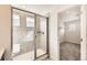 Bathroom featuring walk-in shower with glass doors, neutral tile, and view into the walk-in closet at 17632 Datura St, Broomfield, CO 80023
