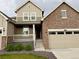 Inviting front exterior showing a charming porch, two-car garage, and meticulously kept landscaped grounds at 17632 Datura St, Broomfield, CO 80023