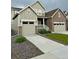 View of the home's front exterior showing a two-car garage, adjacent single-car garage, and inviting front yard at 17632 Datura St, Broomfield, CO 80023