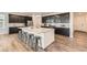 Bright kitchen with dark cabinets, stainless appliances, a large island with bar seating, and wood flooring at 17632 Datura St, Broomfield, CO 80023
