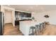 Bright kitchen with white countertops, dark cabinets, stainless steel appliances, and an island with barstools at 17632 Datura St, Broomfield, CO 80023