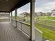 Inviting porch view with wood flooring and white railings, overlooking a community and fenced yard at 17632 Datura St, Broomfield, CO 80023