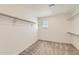 Spacious walk-in closet featuring neutral walls, carpet flooring, and ample storage shelves with metal support at 17632 Datura St, Broomfield, CO 80023