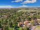 An aerial shot of a house with surrounding lush trees in a neighborhood under a blue sky at 8409 Lightening View Dr, Parker, CO 80134