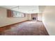 Basement den with brick fireplace, shuttered window, carpet and track lighting at 8409 Lightening View Dr, Parker, CO 80134