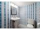 Cozy bathroom features blue and white striped wallpaper, pedestal sink, and a toilet at 8409 Lightening View Dr, Parker, CO 80134