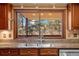 Kitchen sink with granite counters and a window view of the wooded back yard at 8409 Lightening View Dr, Parker, CO 80134