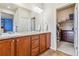 Well-lit bathroom featuring double vanity, granite countertops, and a walk-in closet at 6284 Orion Ct # B, Arvada, CO 80403