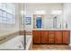 Luxurious bathroom featuring a soaking tub, double vanities, and a glass-enclosed shower, offering a spa-like experience at 6284 Orion Ct # B, Arvada, CO 80403