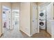 Hallway featuring a stacked washer and dryer and access to multiple rooms at 6284 Orion Ct # B, Arvada, CO 80403