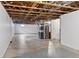 Unfinished basement with exposed wood beams, concrete floor, and white walls at 15427 E Oberlin Pl, Aurora, CO 80013