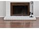 A close up of a fireplace with dark wood floors and neutral colored brick at 15427 E Oberlin Pl, Aurora, CO 80013