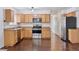 Modern kitchen with stainless steel appliances, subway tile backsplash, and hardwood floors at 15427 E Oberlin Pl, Aurora, CO 80013